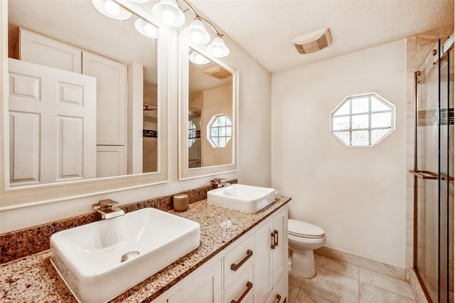 full bathroom featuring toilet, tile patterned flooring, a sink, and a shower stall