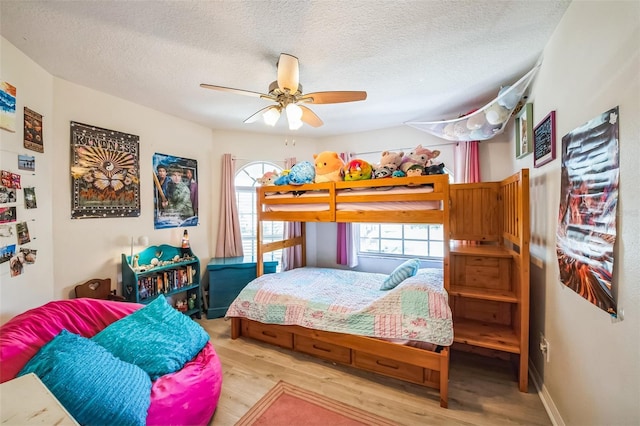 bedroom featuring ceiling fan, a textured ceiling, and wood finished floors