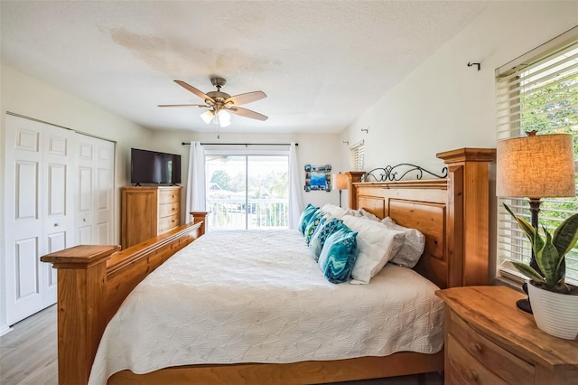 bedroom featuring a ceiling fan, access to outside, a textured ceiling, light wood-type flooring, and a closet