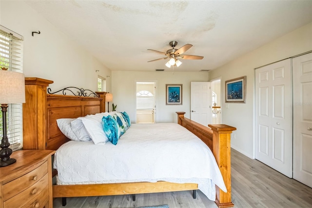 bedroom featuring visible vents, connected bathroom, ceiling fan, light wood-style floors, and a closet