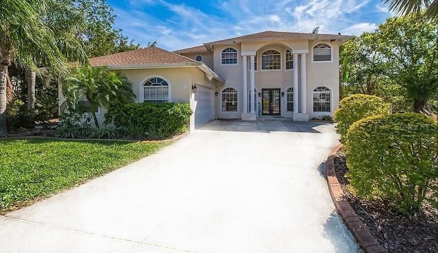 mediterranean / spanish home with driveway, stucco siding, a garage, and french doors