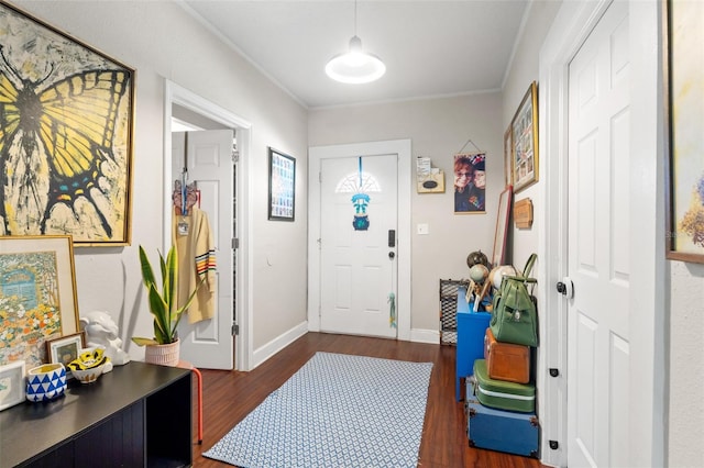 entrance foyer with crown molding, dark wood finished floors, and baseboards