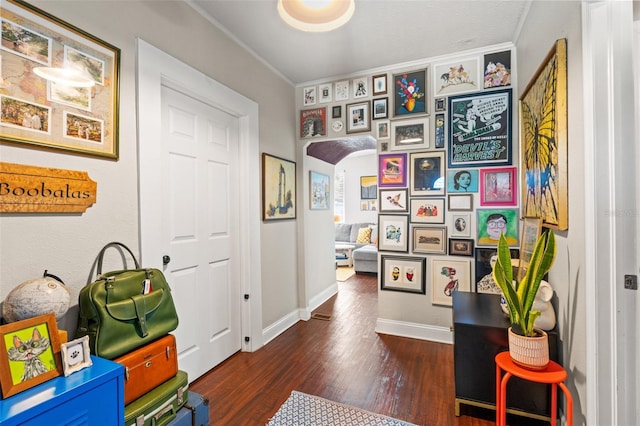 interior space with arched walkways, wood finished floors, and baseboards