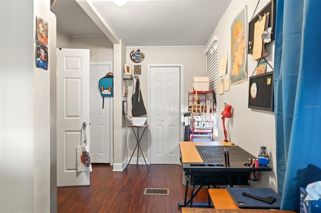 corridor featuring baseboards, visible vents, and wood finished floors