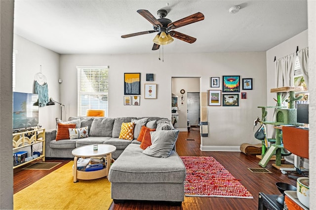 living room featuring ceiling fan, a textured ceiling, wood finished floors, and baseboards