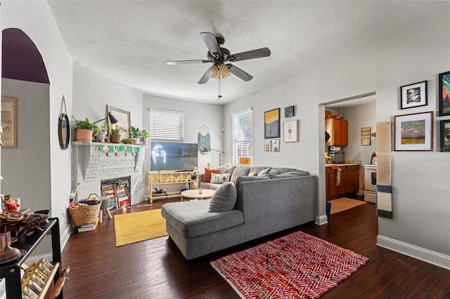 living room with a ceiling fan, baseboards, and wood finished floors