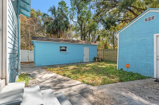 view of outbuilding with fence and an outbuilding