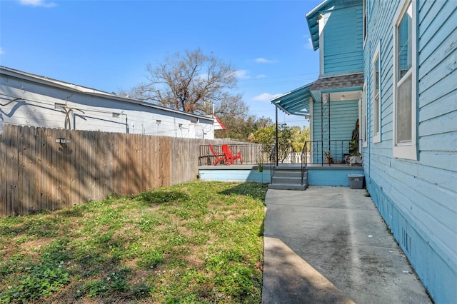 view of yard with covered porch and fence