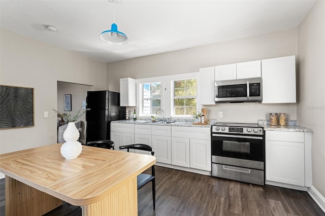 kitchen featuring dark wood-style floors, appliances with stainless steel finishes, a sink, and white cabinetry