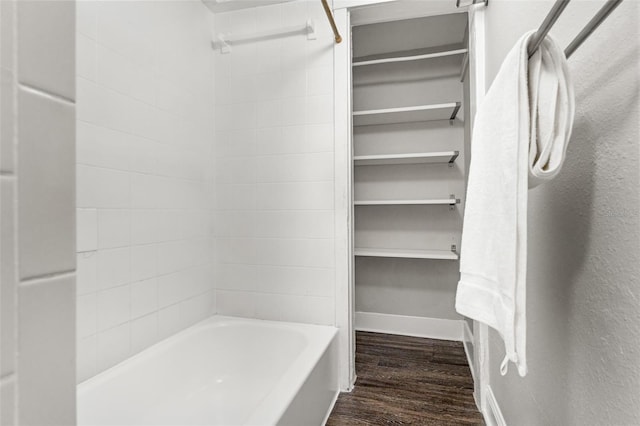 walk in closet with dark wood-style flooring