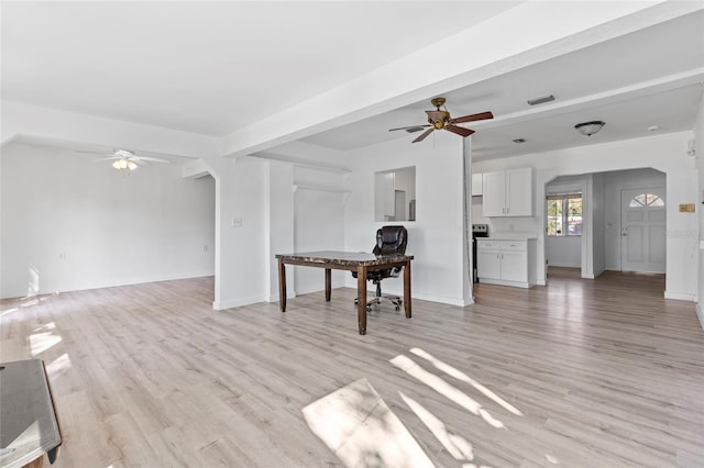 living room with arched walkways, baseboards, light wood-style floors, and a ceiling fan