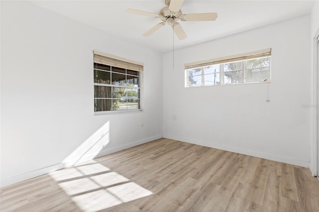 spare room featuring ceiling fan, baseboards, and wood finished floors