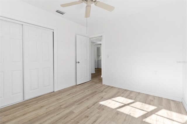 unfurnished bedroom featuring visible vents, wood finished floors, a closet, baseboards, and ceiling fan