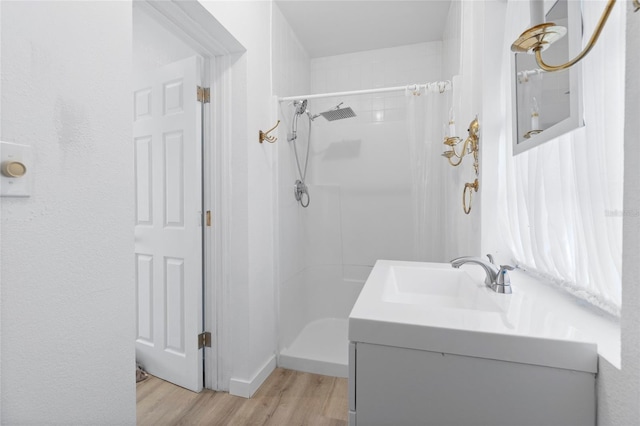 full bathroom featuring vanity, a shower with shower curtain, and wood finished floors