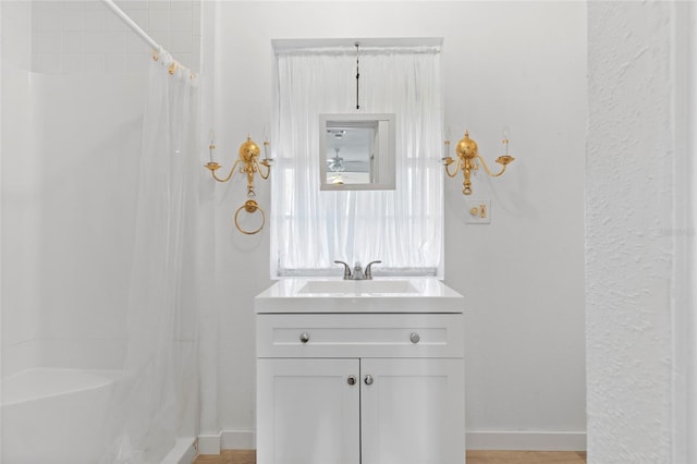 full bath featuring vanity, curtained shower, and baseboards