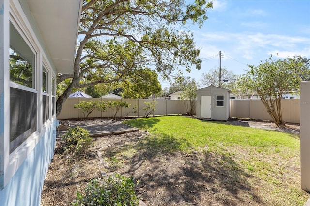 view of yard featuring a fenced backyard, a storage shed, and an outdoor structure