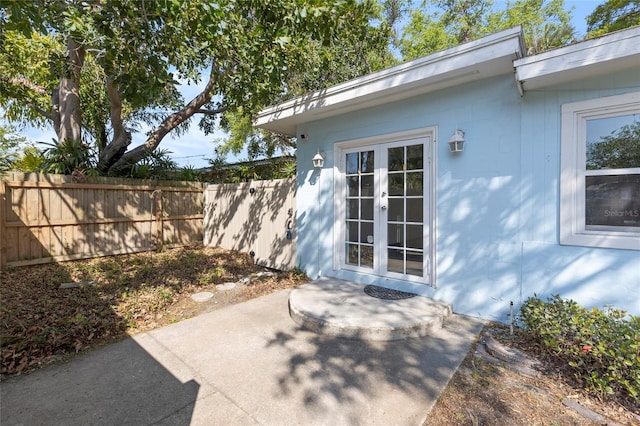 view of patio with french doors and fence