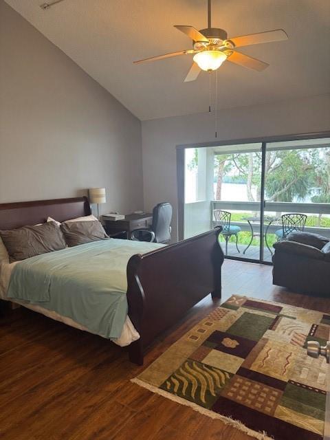 bedroom with access to exterior, ceiling fan, high vaulted ceiling, and wood finished floors