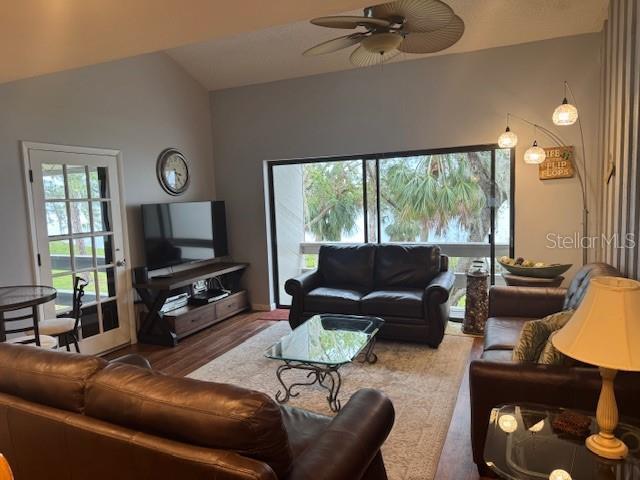 living room featuring lofted ceiling, a wealth of natural light, and a ceiling fan