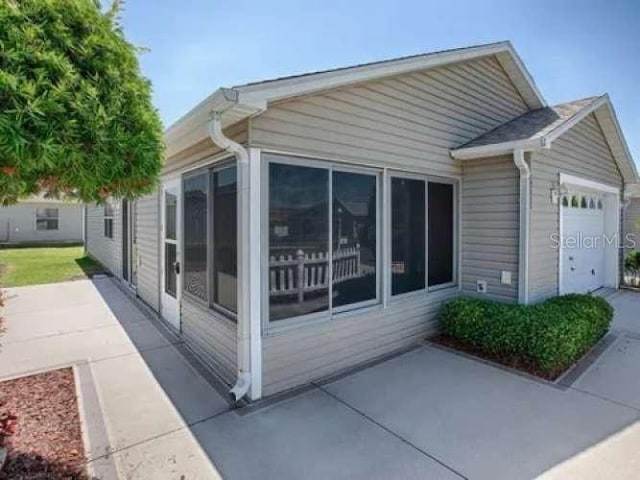 view of side of property with a garage and a sunroom