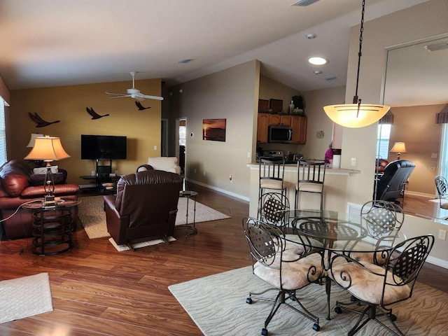 living room featuring lofted ceiling, wood finished floors, visible vents, and baseboards