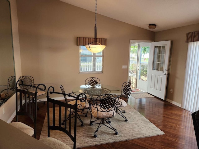 dining space with dark wood-style floors, baseboards, and vaulted ceiling