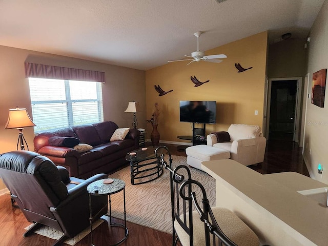 living room featuring ceiling fan, vaulted ceiling, a textured ceiling, and wood finished floors