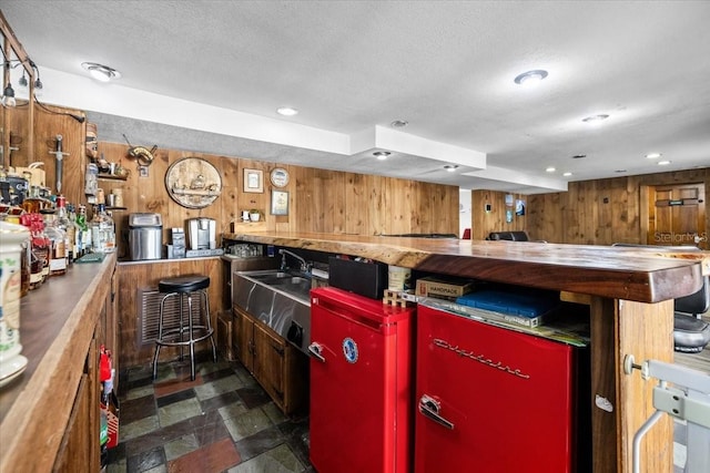 bar featuring recessed lighting, a textured ceiling, and wood walls