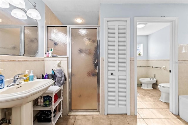 bathroom featuring tile walls, tile patterned floors, a bidet, and a closet