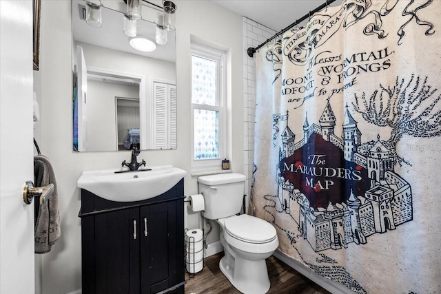 bathroom with a shower with curtain, toilet, wood finished floors, and vanity