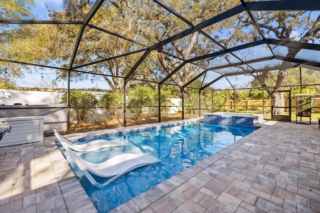 view of swimming pool featuring a patio, fence, a pool with connected hot tub, and a lanai