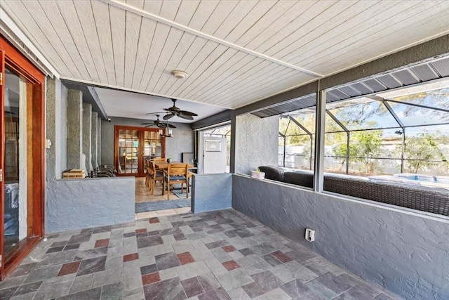 unfurnished sunroom featuring wooden ceiling and a ceiling fan