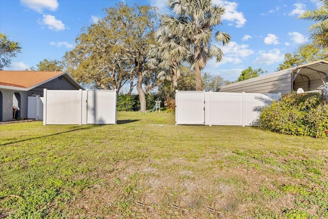 view of yard featuring a detached carport and fence