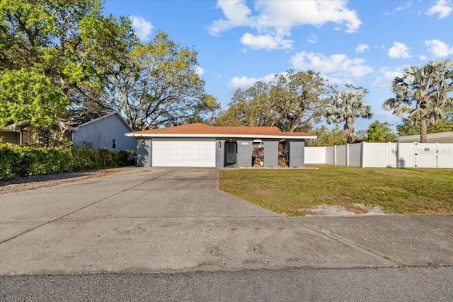 view of front of property featuring fence, concrete driveway, a front yard, stucco siding, and a garage