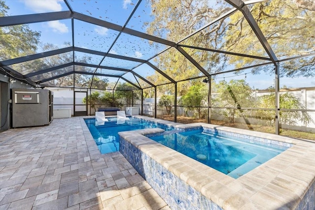 view of pool with a lanai, a patio area, and a pool with connected hot tub