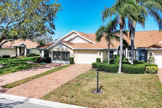 ranch-style home with a front lawn, decorative driveway, an attached garage, and stucco siding