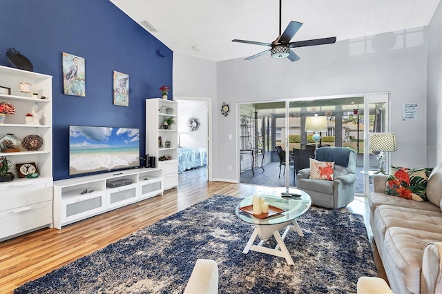 living area featuring a ceiling fan, visible vents, and wood finished floors