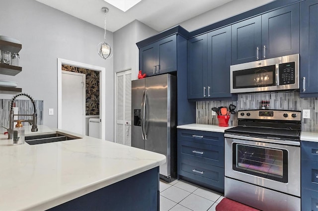 kitchen featuring blue cabinetry, light tile patterned floors, stainless steel appliances, backsplash, and a sink