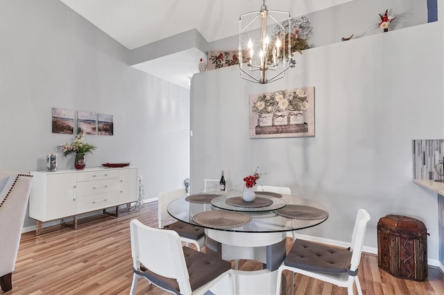 dining room with baseboards, wood finished floors, and a notable chandelier