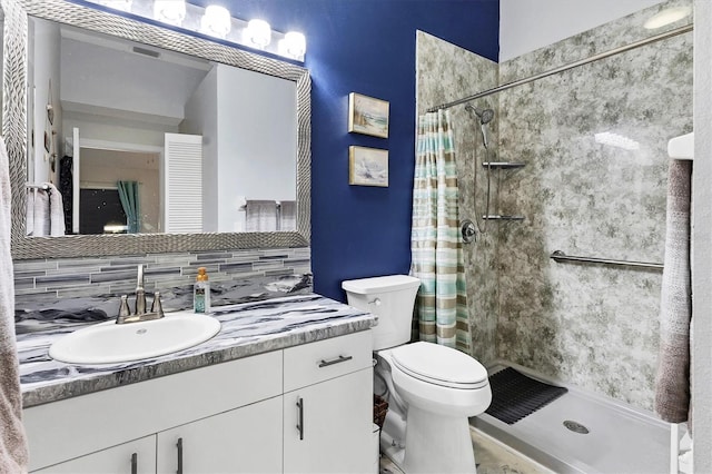 bathroom with vanity, a shower stall, toilet, and decorative backsplash