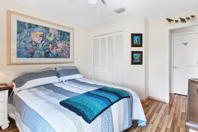 bedroom with a ceiling fan, a closet, baseboards, and wood finished floors