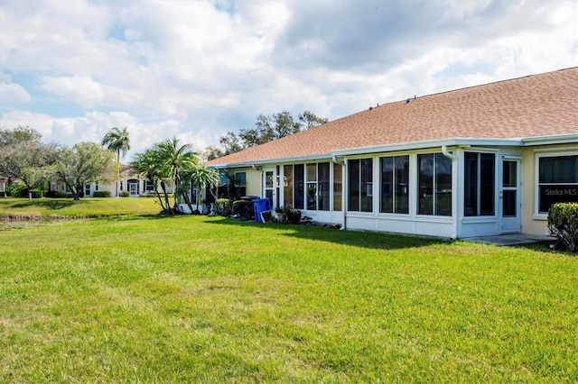 rear view of property with a sunroom and a yard