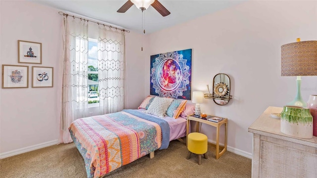 bedroom with a ceiling fan, light carpet, and baseboards