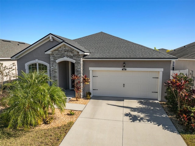 view of front of property with stone siding, an attached garage, driveway, and stucco siding