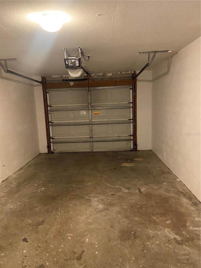 garage with concrete block wall and a garage door opener