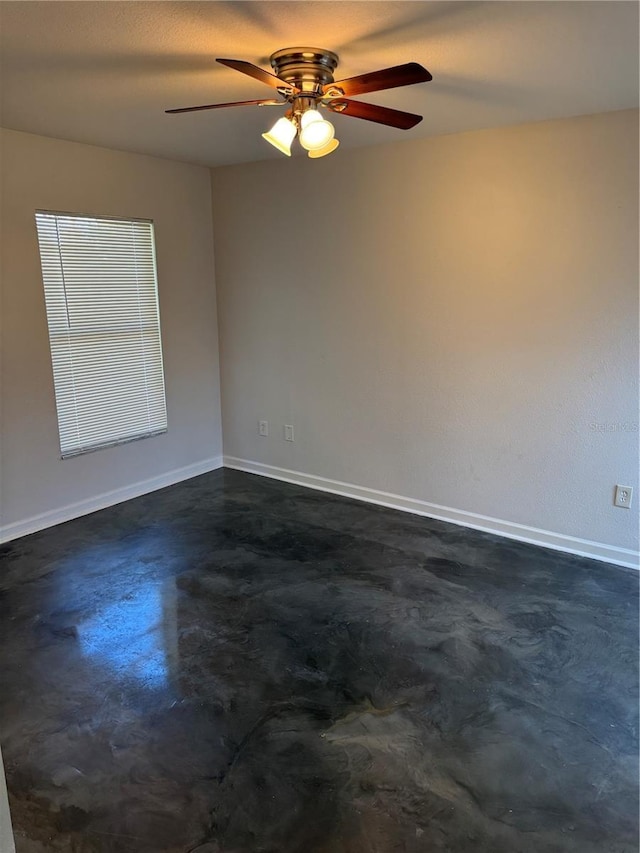 empty room featuring concrete floors and baseboards