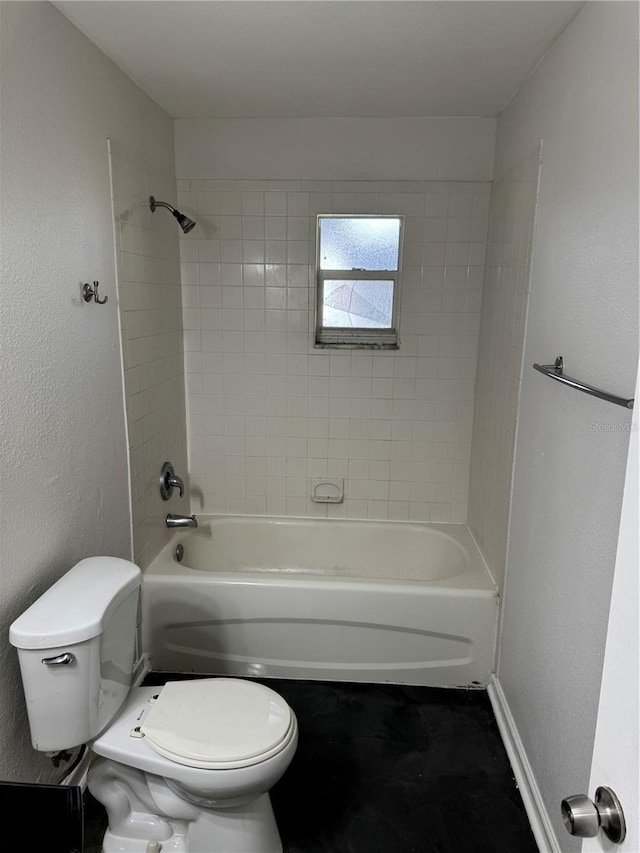 full bathroom with a textured wall, shower / bathing tub combination, toilet, and baseboards