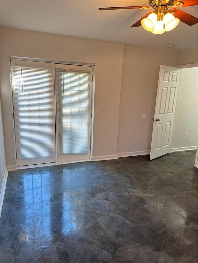 empty room featuring a wealth of natural light, ceiling fan, and baseboards