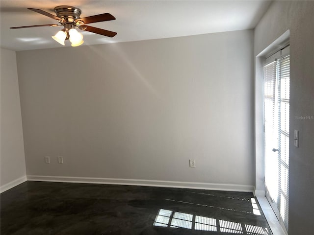 empty room featuring ceiling fan and baseboards