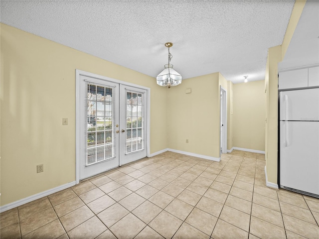 unfurnished dining area with baseboards, light tile patterned flooring, a textured ceiling, and french doors